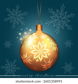 A golden Christmas sphere with a flower pattern set against a blue background with snowflakes.