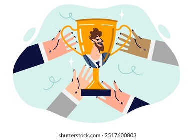 Golden cup with man face in hands of business people symbolizes teamwork and receiving trophy for professionalism. Managers received golden cup for best work among different departments of corporation