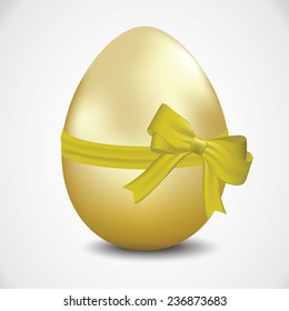 Golden egg with a ribbon and a bow.