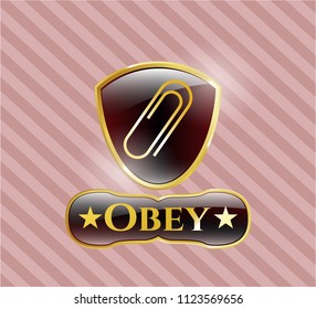  Golden emblem or badge with paper clip icon and Obey text inside