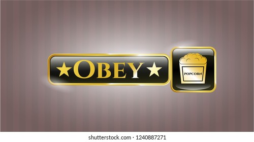  Golden emblem or badge with popcorn icon and Obey text inside