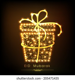 Golden gift box decorated with floral design on brown background for Muslim community festival Eid Mubarak celebrations. 
