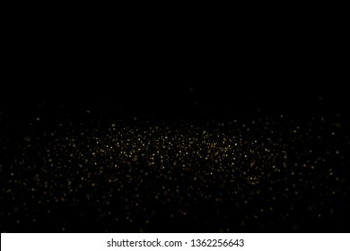 Golden glitter dust explosion on black background