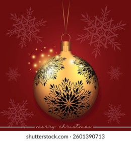 A golden holiday bauble displaying a snowflake pattern against a red snowy background.