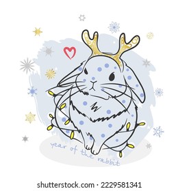 Golden horns on the rabbit, year of the rabbit, handwritten inscription on the background of snowflakes, garland, holiday card