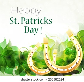 Golden horseshoes on clover background with place for text.  St. Patrick's Day background.