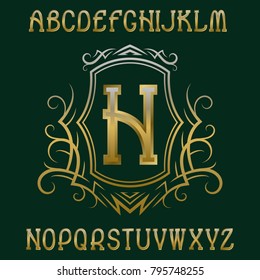 Golden initial monogram template in wreath with shield. Graceful alphabet and logo design elements.