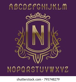 Golden initial monogram template in wreath with shield. Patterned letters and logo design elements.