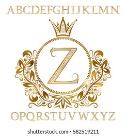 Golden patterned letters with initial monogram in coat of arms form. Shining font and elements kit for logo design.