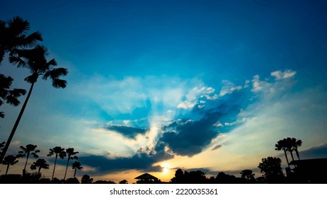 The golden sky mixed with indigo reflected the light of the setting sun Let the dark shadows in the lower part of the trees focus on the sun intended content There is little light in some parts