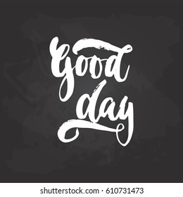 Good day - hand drawn lettering phrase on the black chalkboard background. Fun brush ink inscription for photo overlays, greeting card or t-shirt print, poster design