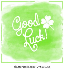 Good Luck! Lettering with a four-leaf clover on light green watercolor background with a simple square frame. Vector.