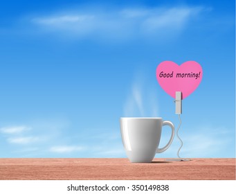 Good Morning In Pink Heart Note With Hot Drink On Wood Table On Sky Background
