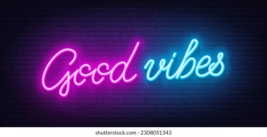 Good Vibes neon lettering on brick wall background.