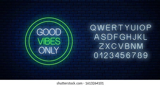 Good vibes only - glowing neon inscription phrase in green circle frame with alphabet on dark brick wall background. Motivation quote in neon style. Vector illustration.