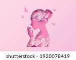 A graceful pink paper-cut woman silhouette with floral elements, symbolizing elegance, love, and strength of women on International Women's Day.