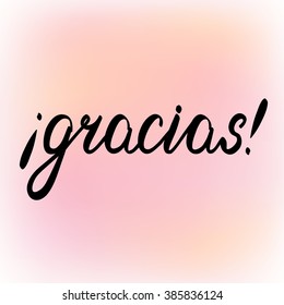 Gracias. Thank you in Spanish, brush hand lettering. Brush calligraphy on a cheerful blurred background.