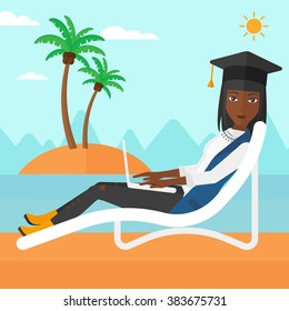 Graduate lying on chaise lounge with laptop.