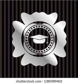 graduation cap icon inside silvery emblem or badge