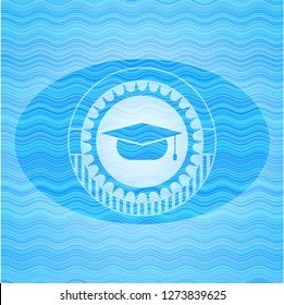 graduation cap icon inside sky blue water badge background.