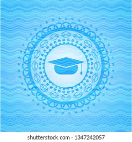 graduation cap icon inside sky blue water wave badge.