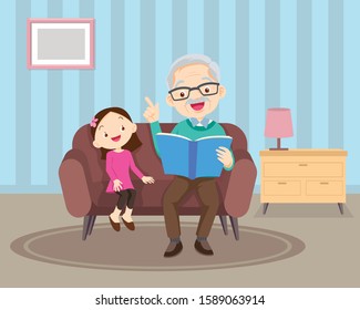 Grandfather sitting with grandchildren on sofa with the book