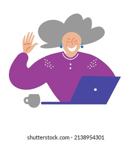 Grandma is sitting with laptop. An elderly woman using a computer. Modern technology and the elderly. A pretty elderly smiling lady with gray hair sits with a cup of tea and communicates on computer