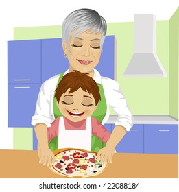 Grandmother with her grandson preparing delicious pizza together in kitchen
