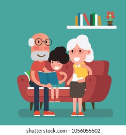 Grandparents and granddaughter  sitting in sofa and reading book