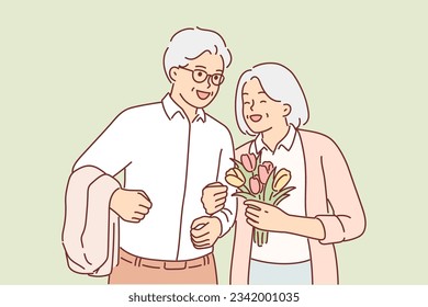 Grandparents in love during date or marriage ceremony, for concept of love in old age. Grandmother with flowers presented by grandfather in honor of anniversary of wedding or beginning life together