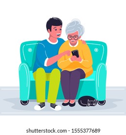 Grandson helping grandmother to use cellphone. Boy showing old woman how to make a call with mobile phone. Two characters sitting on the sofa and holding gadget and cat lying. Vector flat illustration