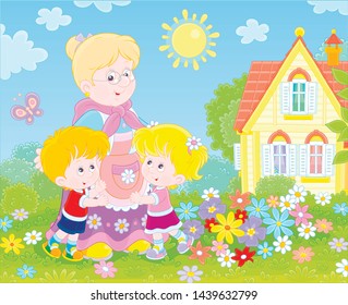Granny and her little grandchildren smiling and hugging among colorful flowers on a green lawn in front of a village house on a sunny summer day, vector illustration in a cartoon style
