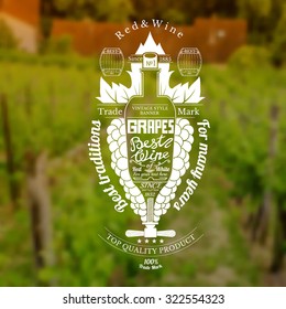 Grapes bunch with bottle for text in the center wine label on blurred vineyards background
