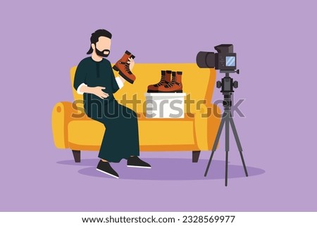 Graphic flat design drawing social media influencer reviewing boots. Young Arabian man vlogging about men's sports shoe and filming himself at home on video camera. Cartoon style vector illustration