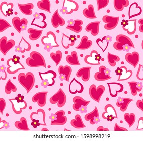 Graphic Hearts in Shades of Pinks in Repeat tossed around randomly with Spots of White and tiny Graphic Daisies on top.