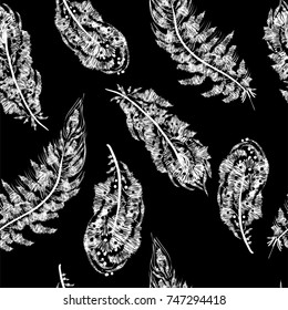 Graphic seamless pattern with the image of bird feathers arranged in a chaotic manner. Monochrome. Imitation of embroidery on fabric. Vector illustration. Black and white. Hand drawing.