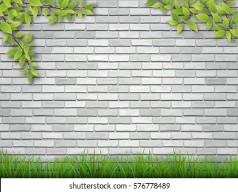 Grass and tree branches on white brick wall background.