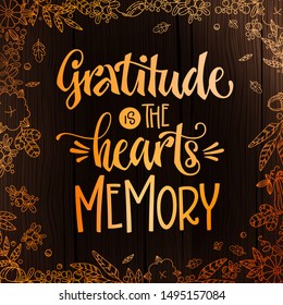 Gratitude is the Hearts memory - quote. Thanksgiving dinner theme hand drawn lettering phrase. Logo, text design. Pumpkin, leaves, cotton design.  Orange text on dark wood background. 