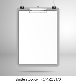 Gray clipboard with a blank white sheet of paper hang on clips above the surface. Mockup for design