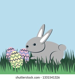 Gray Easter egg rabbit in the green grass.