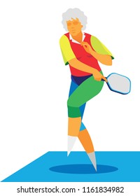 A gray-haired active woman is a pensioner who plays pickleball in outdoors