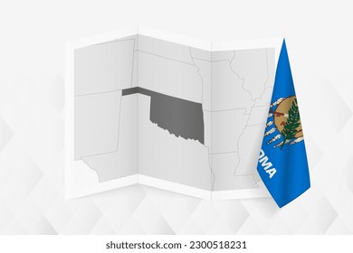 A grayscale map of Oklahoma with a hanging Oklahoma flag on one side. Vector map for many types of news. Vector illustration.
