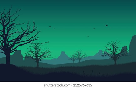 Great view of mountains and forest from the countryside with silhouettes of pine trees around