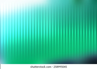 Green abstract blur colored background with defocused vertical rays of light.