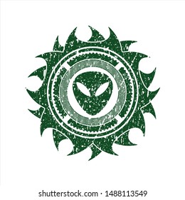 Green alien icon inside distressed rubber grunge texture stamp