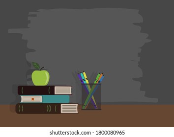 green apple on textbooks next to glass with pencils on the background of the school board
