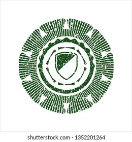 Green armor icon inside distress rubber stamp with grunge texture