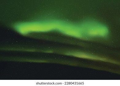 Green aurora borealis. Dark night starry sky and bright polar lights