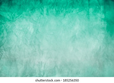 Green background, crumpled paper