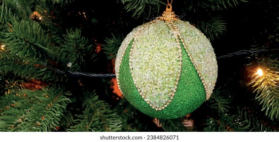 Green ball on a Christmas tree with empty space for text. Christmas decorations, garland and toys. Christmas banner, vector postcard. New Year card, poster with New Year toy.